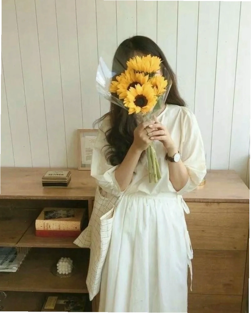Ảnh gái xinh che mặt bằng hoa hướng dương, mang lại năng lượng tích cực và sự tươi mới
