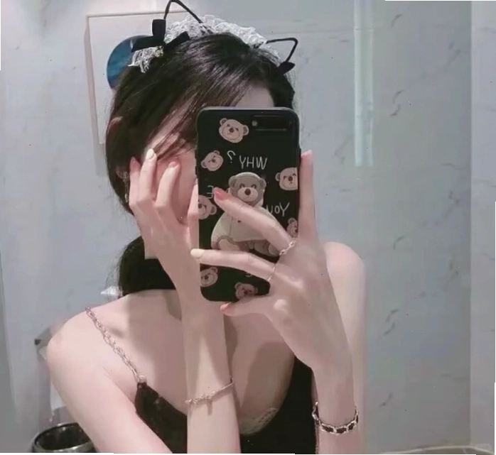 Cô gái che mặt bằng điện thoại khi nhìn vào gương