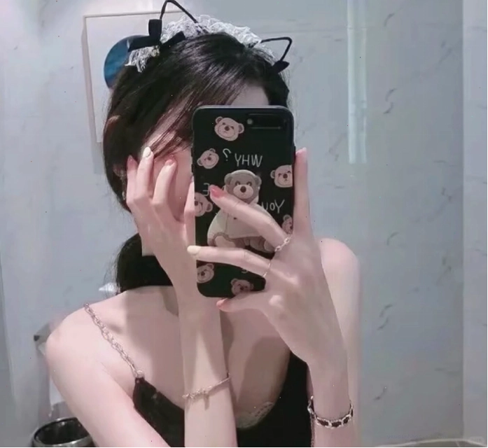 Cô gái che mặt bằng điện thoại trong gương với biểu cảm tinh nghịch