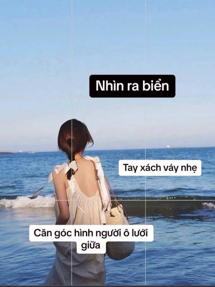 Cô gái đứng trên bãi biển, quay lưng nhìn ra biển khơi
