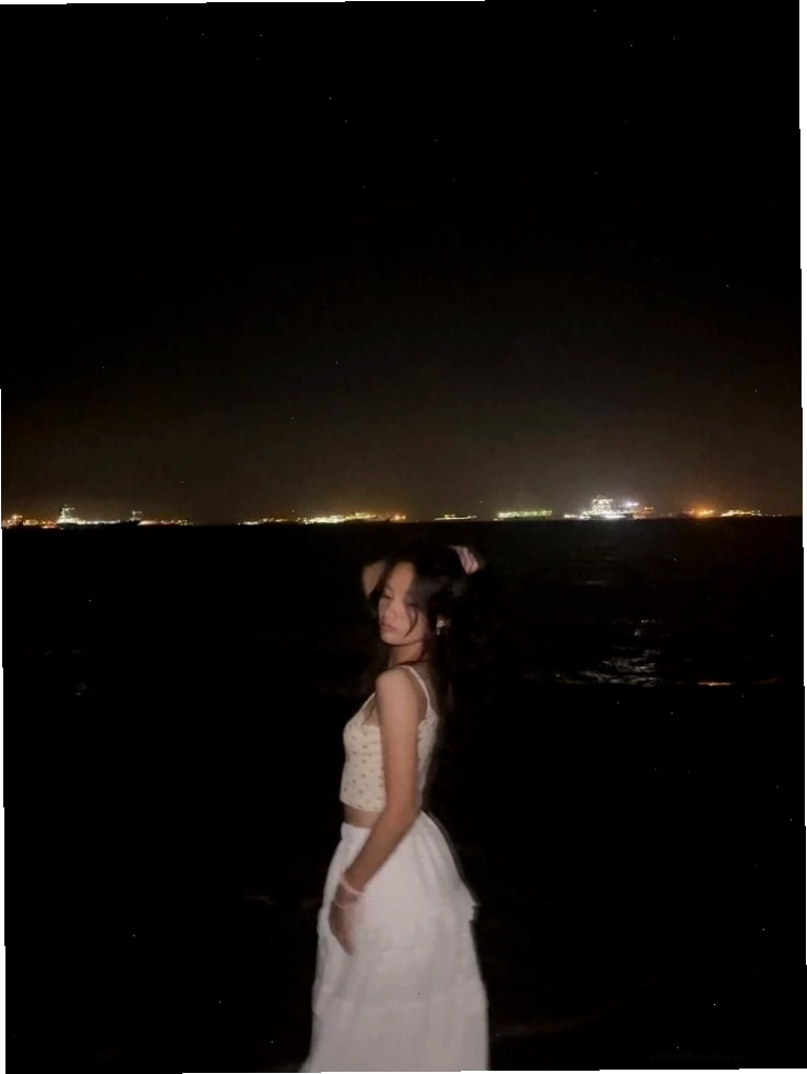 Cô gái quay lưng ngắm nhìn biển đêm