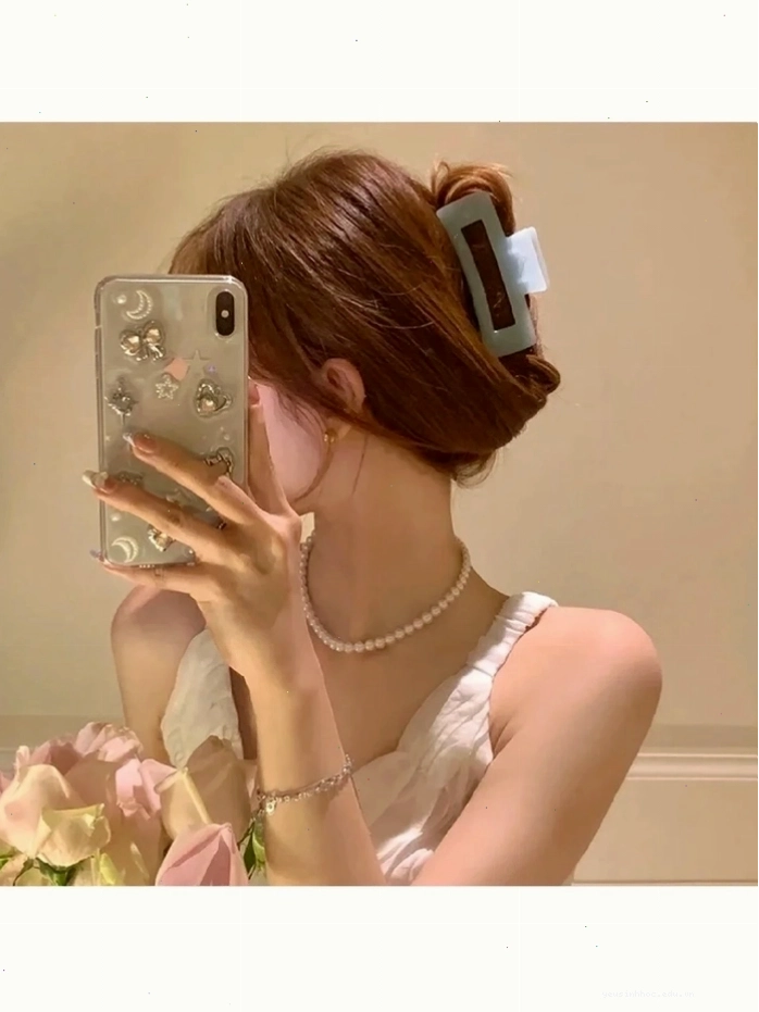 Cô gái trẻ cầm điện thoại che mặt, tạo dáng cuốn hút