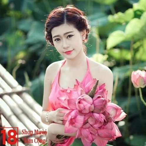 Cô gái trẻ với nụ cười tươi tắn, tay nâng niu đóa hoa sen trắng tinh khôi