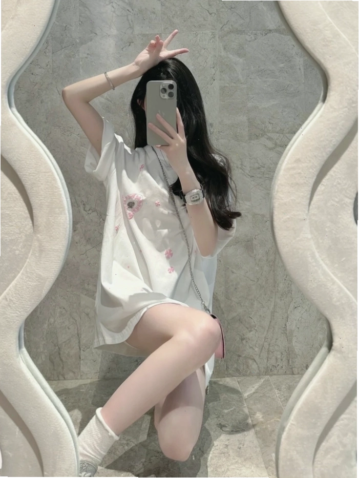 Cô gái xinh đẹp dùng điện thoại che mặt trước gương