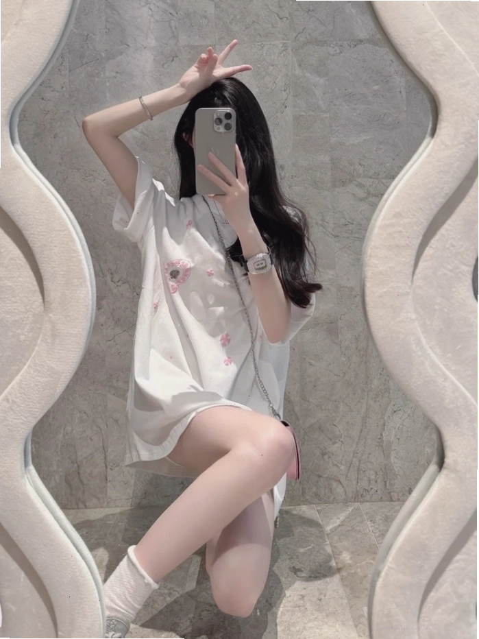 Cô gái xinh đẹp selfie trước gương, dùng điện thoại che mặt