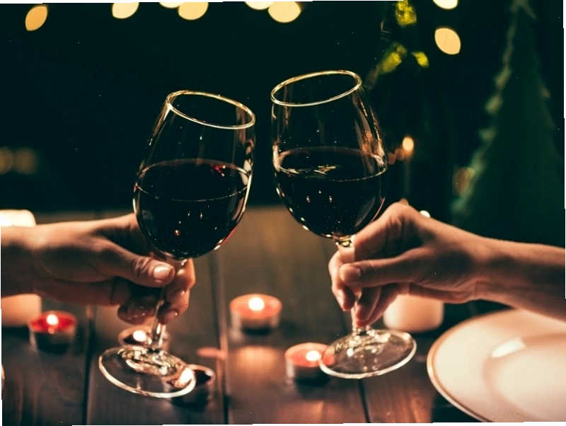 Đôi tay cầm ly rượu với ánh sáng chiếu rọi