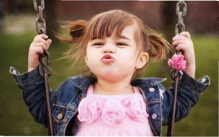 Em bé đang thích thú nhìn vào thứ gì đó và cười khúc khích