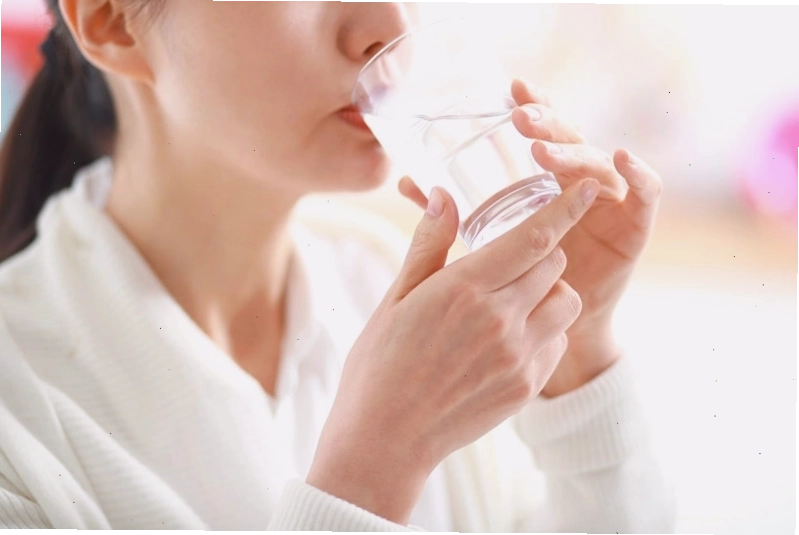 Một người đang uống nước từ bình giữ nhiệt