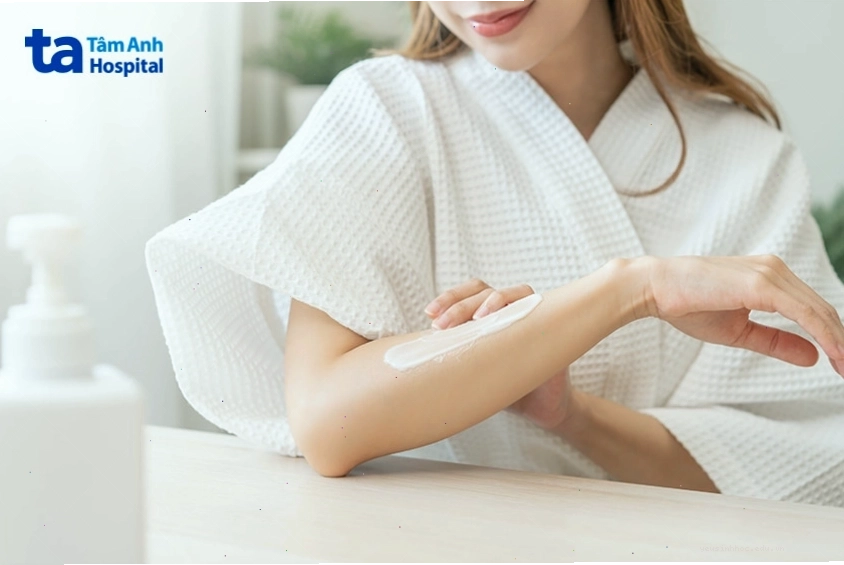 Phụ nữ đang thoa kem dưỡng làm dịu da khi bị kích ứng hoặc nổi mẩn