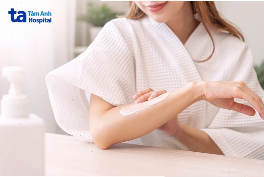 Phụ nữ đang thoa kem dưỡng làm dịu da khi bị kích ứng hoặc nổi mẩn
