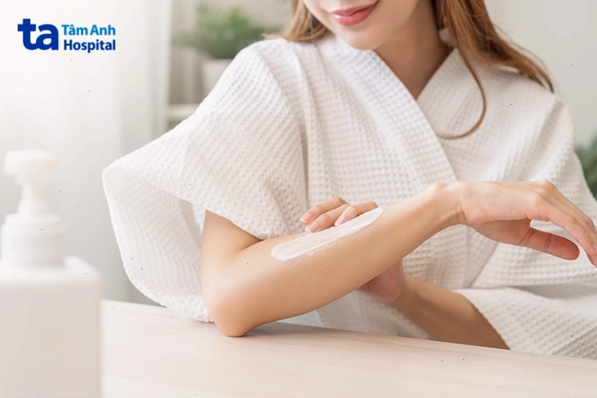 Phụ nữ đang thoa kem dưỡng làm dịu da khi bị kích ứng hoặc nổi mẩn