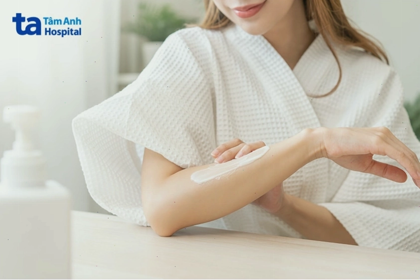 Phụ nữ đang thoa kem dưỡng làm dịu da khi bị kích ứng hoặc nổi mẩn