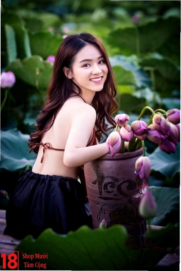 Thiếu nữ trong tà áo dài trắng cầm hoa sen thanh khiết